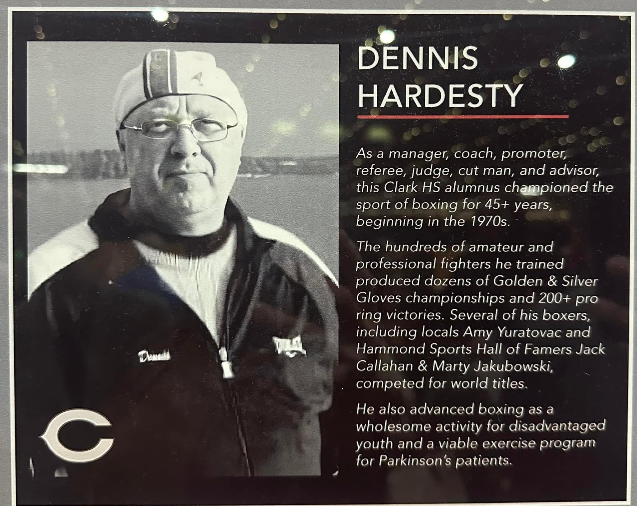The Dennis Hardesty memorial tribute plaque — a black-and-white portrait beside his biography.